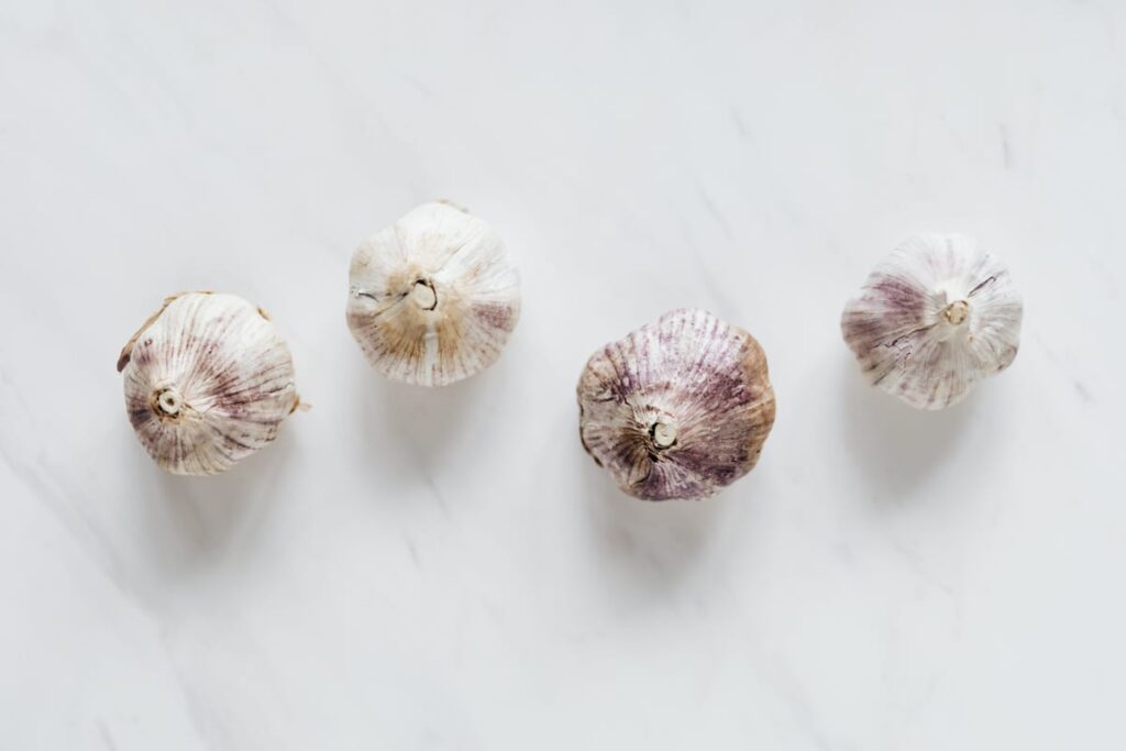 Whole garlic bulbs on a neutral surface, illustrating that garlic is unsafe for dogs